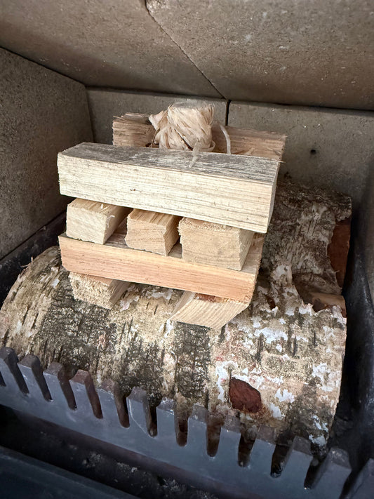 Bed of Birth logs with kindling tower on top and a firelighter representing the top down lighting method